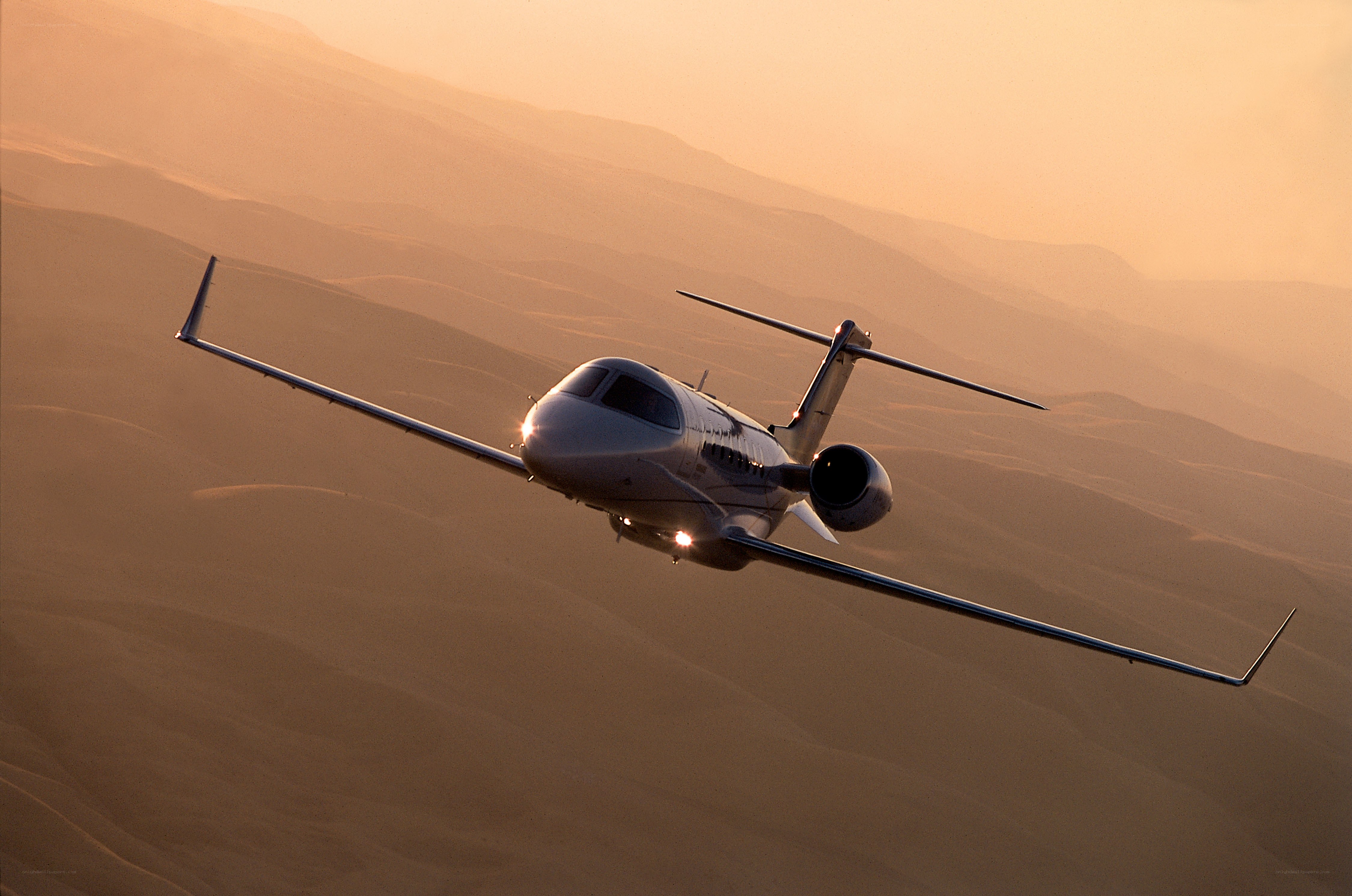 private jet flying over desert