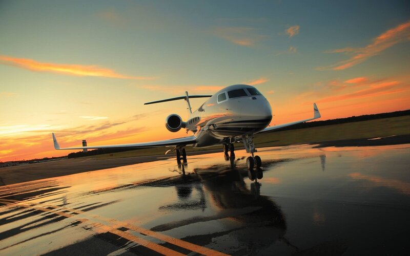 private jet on wet tarmac at sunset
