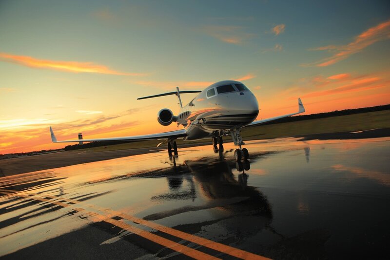 Private jet on wet tarmac at sunset