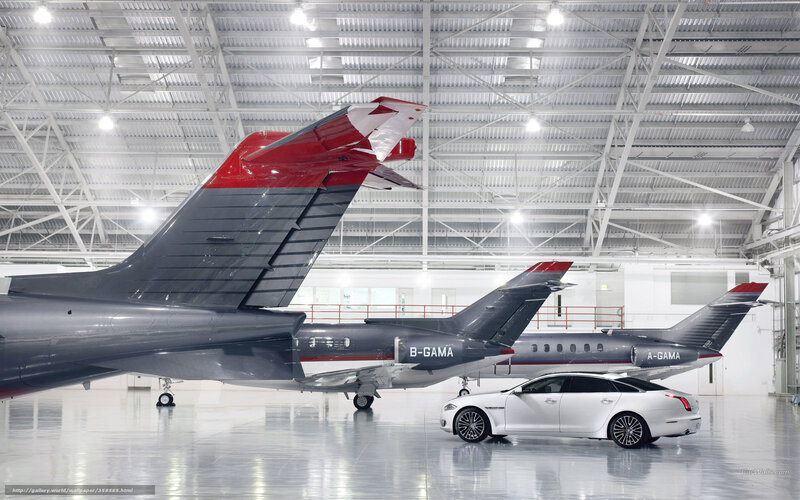 Private jets and luxury car in hangar