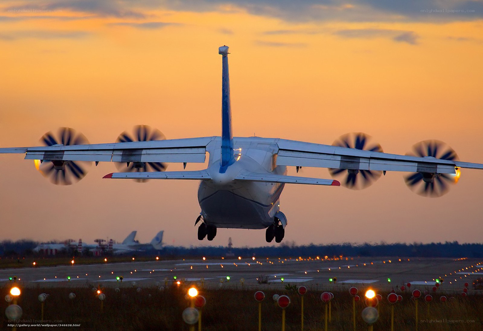 Propeller plane taking off at sunset