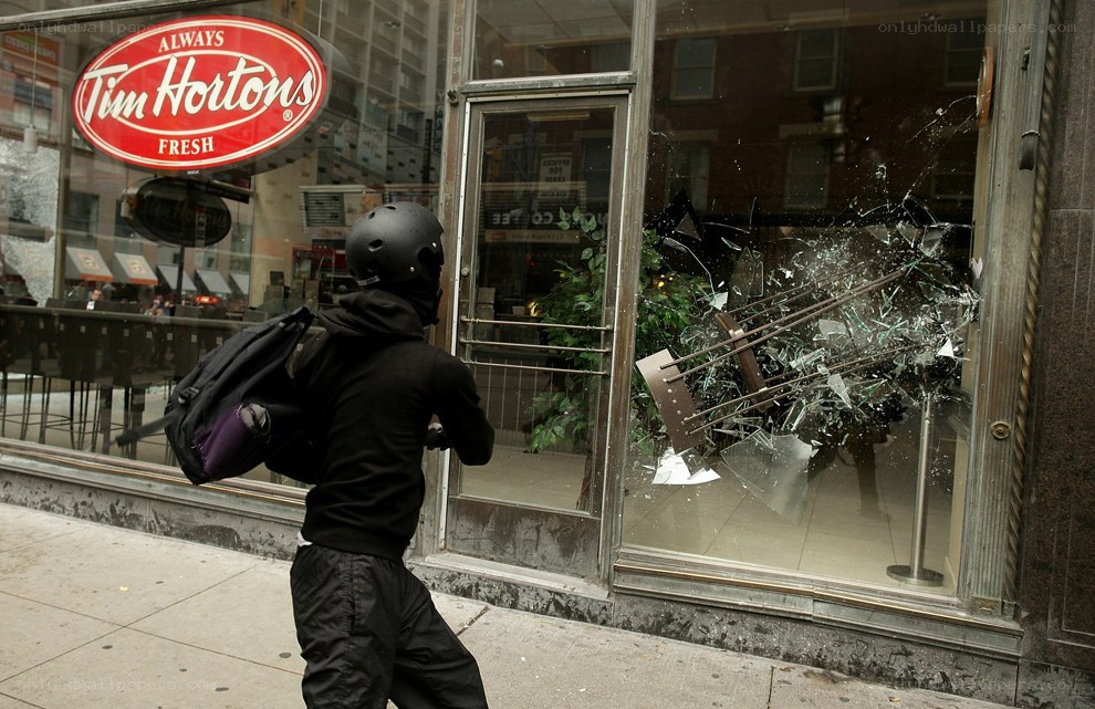 Protester near broken Tim Hortons window