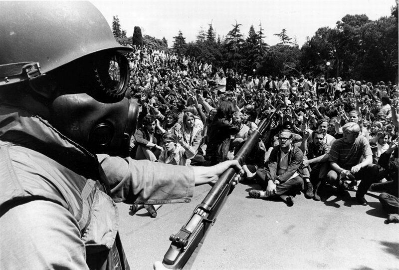 Protesters facing armed soldier
