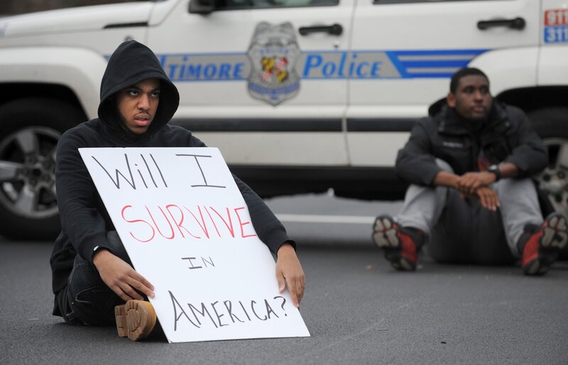 Protesters in front of police car