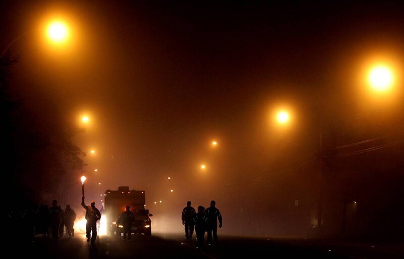 Protesters march at night