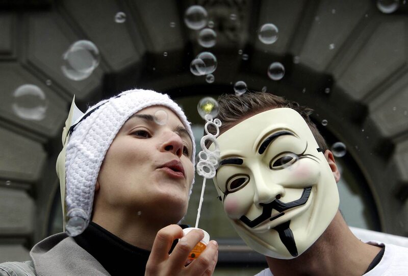 Protesters with masks blowing bubbles