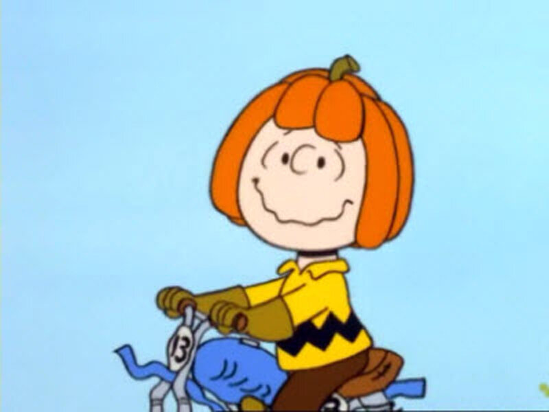 Pumpkin-headed girl on bike