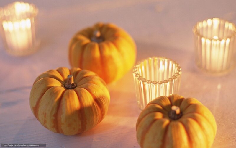Pumpkins and candles on table