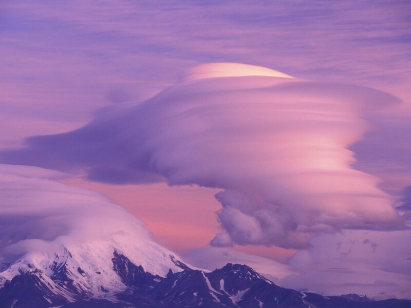 Purple clouds over snow-capped mountains