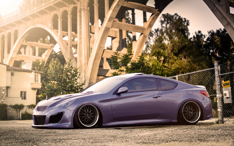 Purple coupe under a bridge