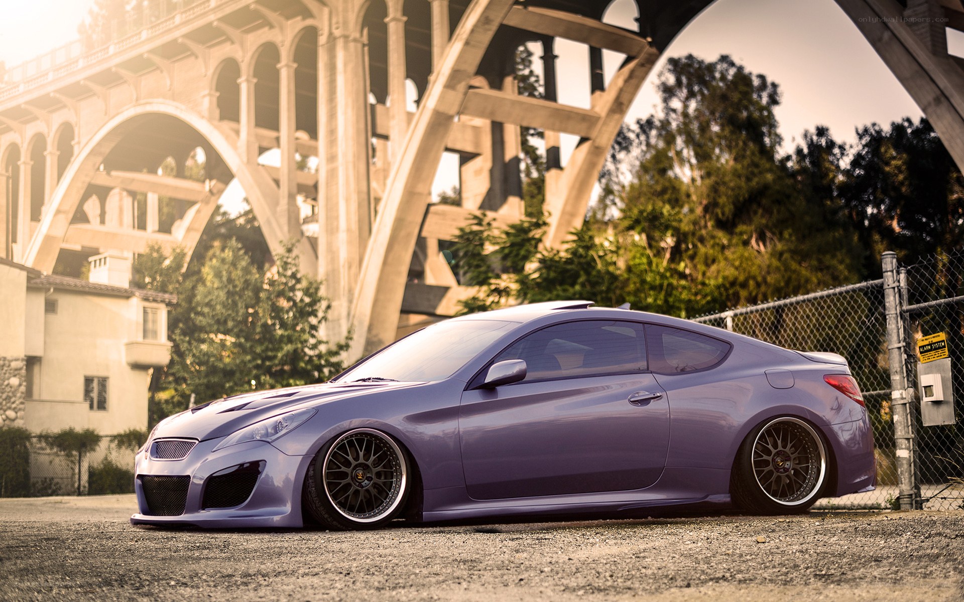 Purple coupe under a bridge