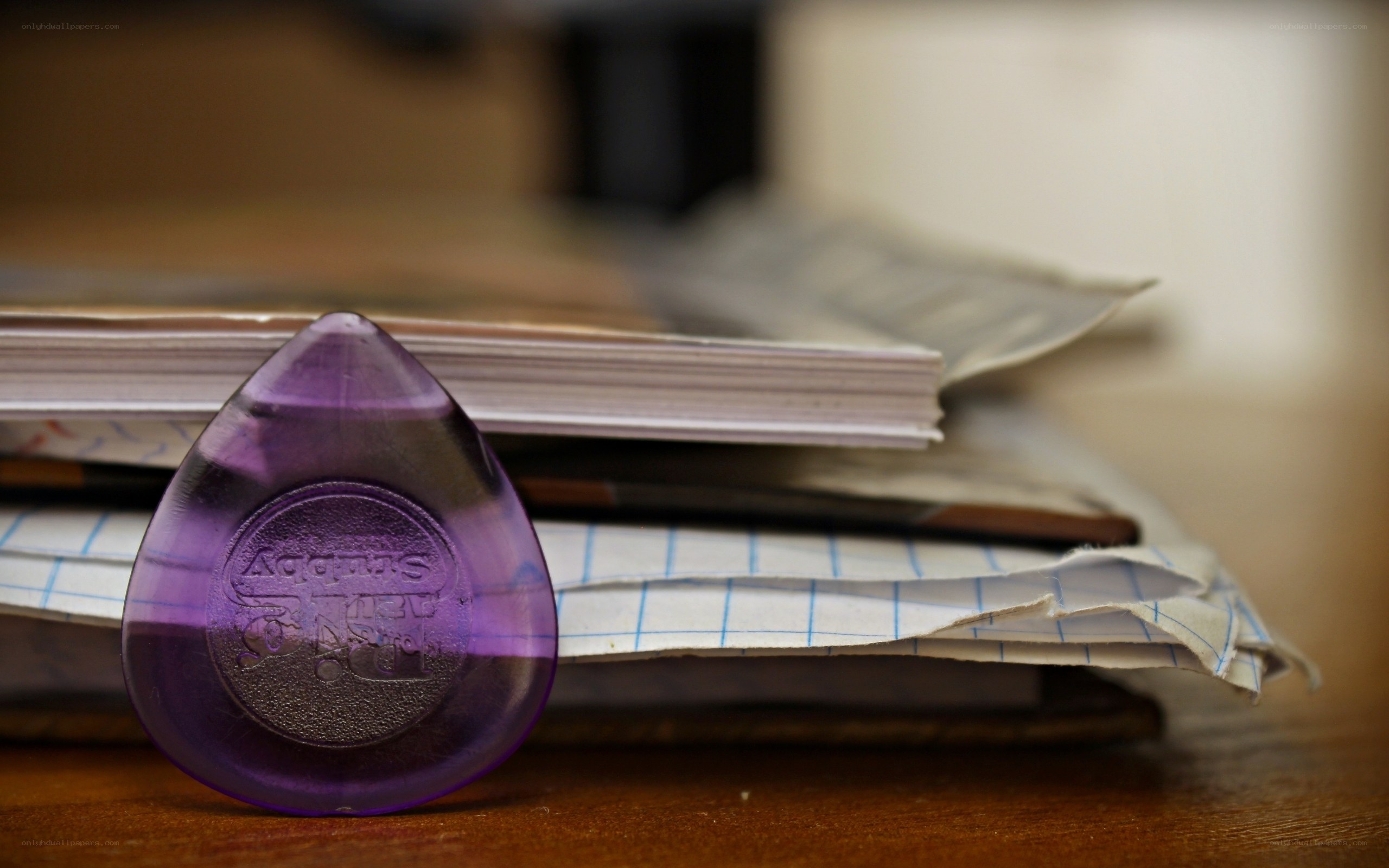 Purple guitar pick on papers