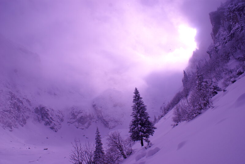 Purple-hued snowy mountain valley