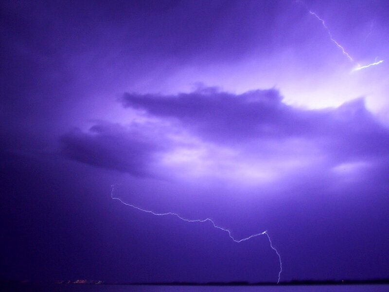 Purple lightning storm over water