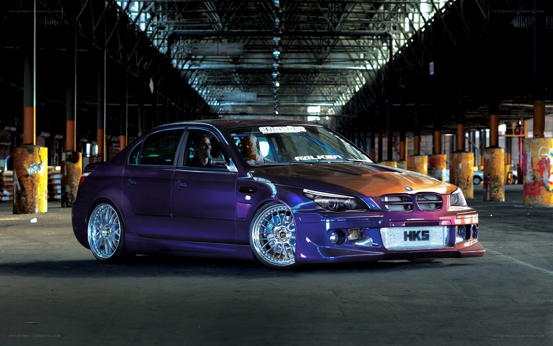 purple modified sedan in warehouse
