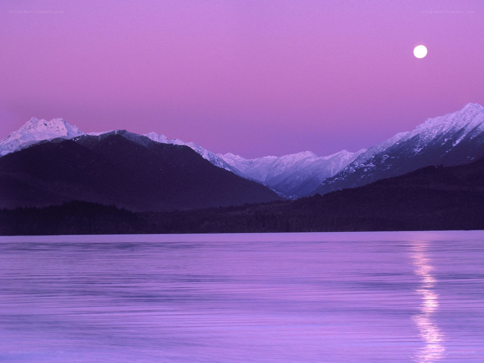 Purple moon over mountain lake