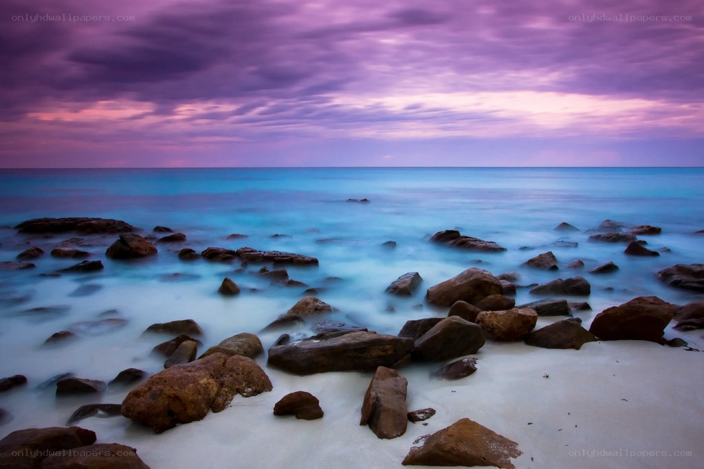 Purple sky over rocky beach