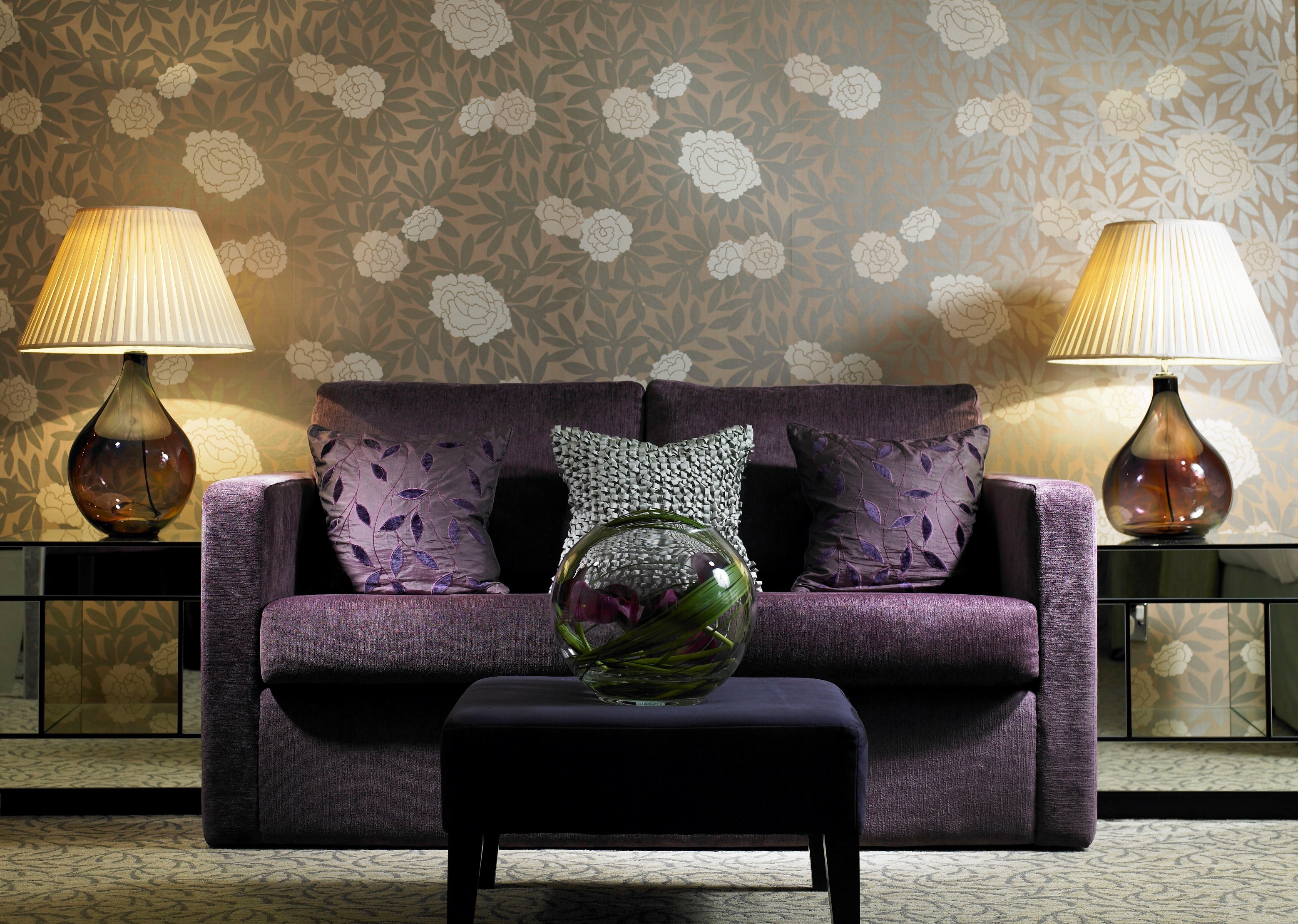 purple sofa with floral wallpaper