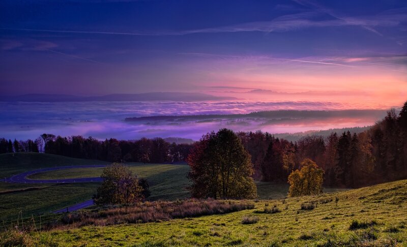 Purple sunrise over foggy valley