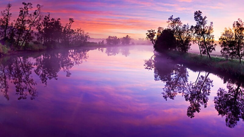 Purple sunrise over misty river