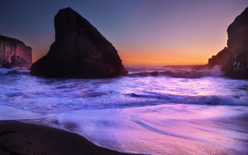 Purple sunset at rocky beach