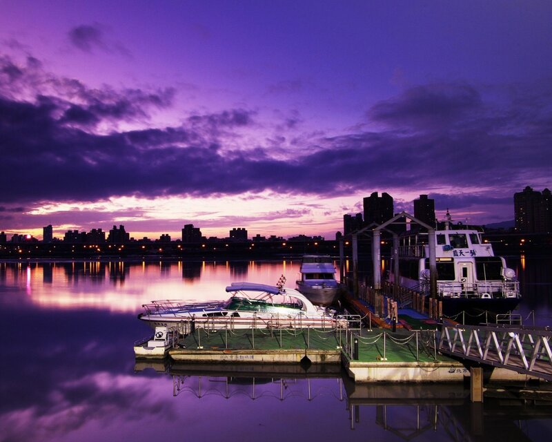 Purple sunset over a city harbor