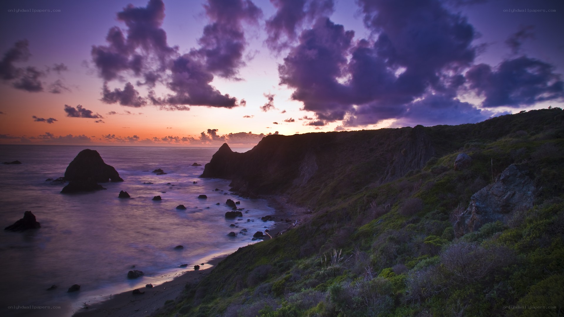 Purple sunset over coastal cliffs