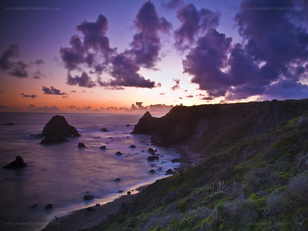 Purple sunset over coastal cliffs
