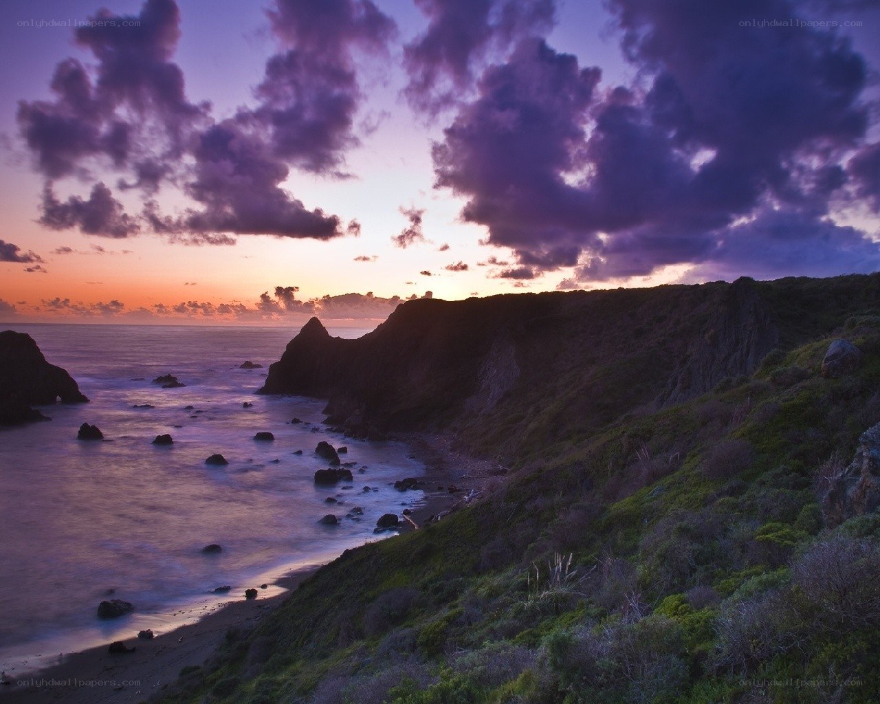 Purple sunset over coastal cliffs