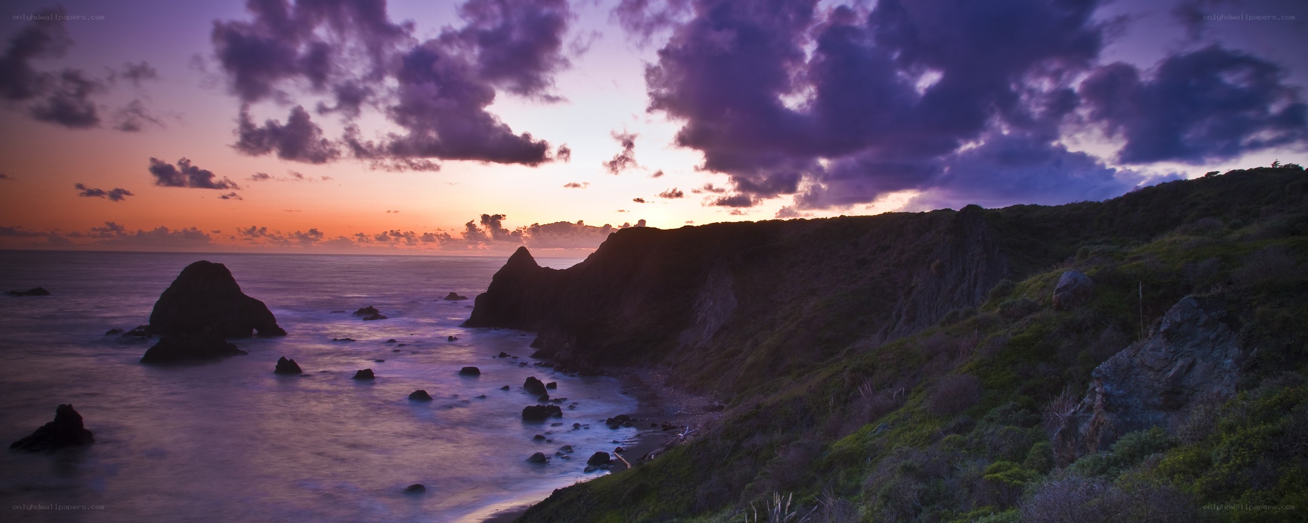 Purple sunset over coastal cliffs