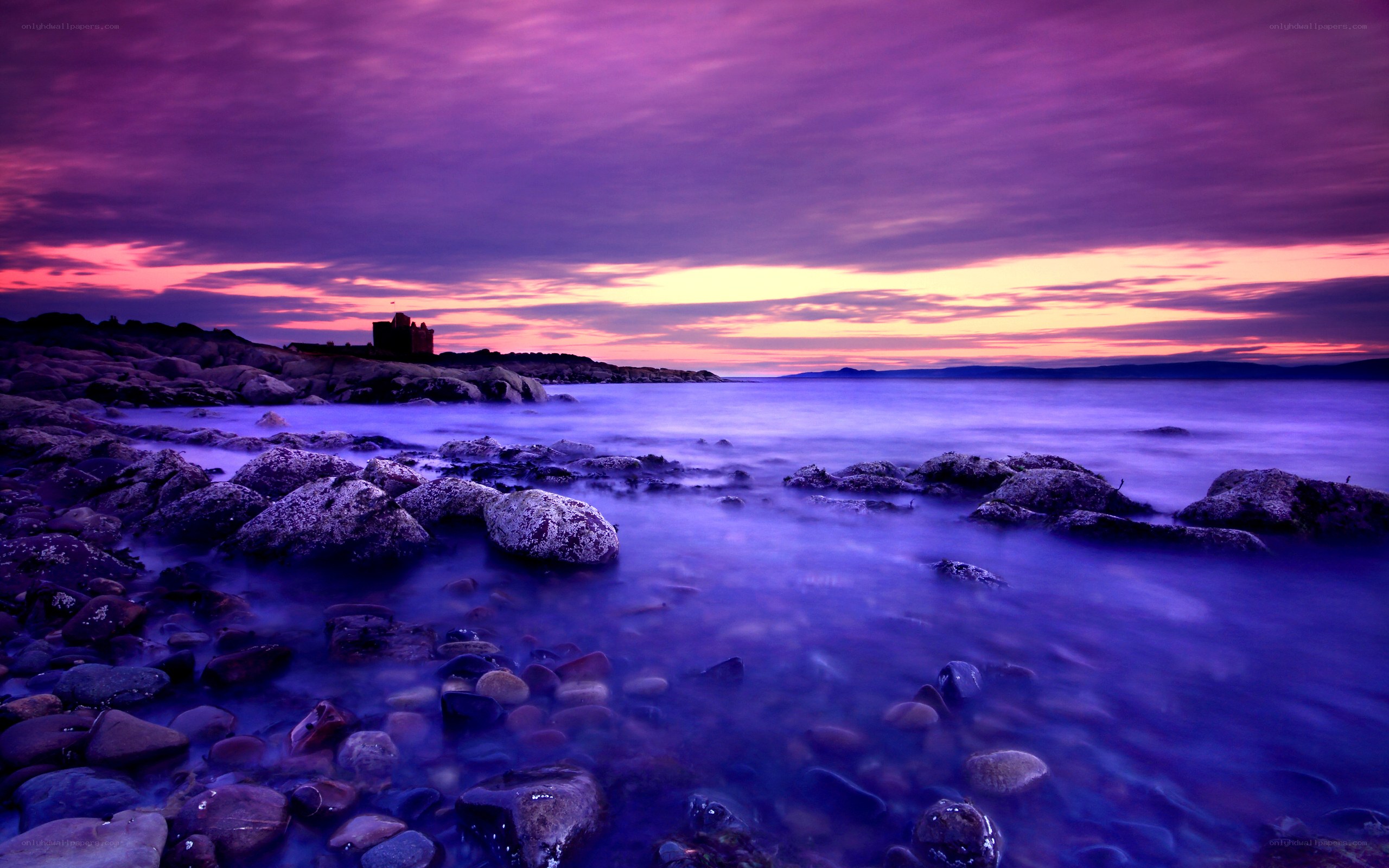 Purple sunset over coastal rocks