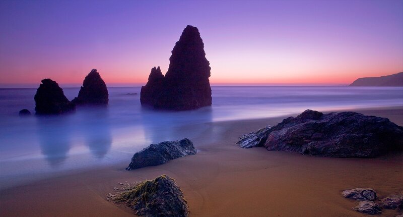 Purple sunset over coastal rocks