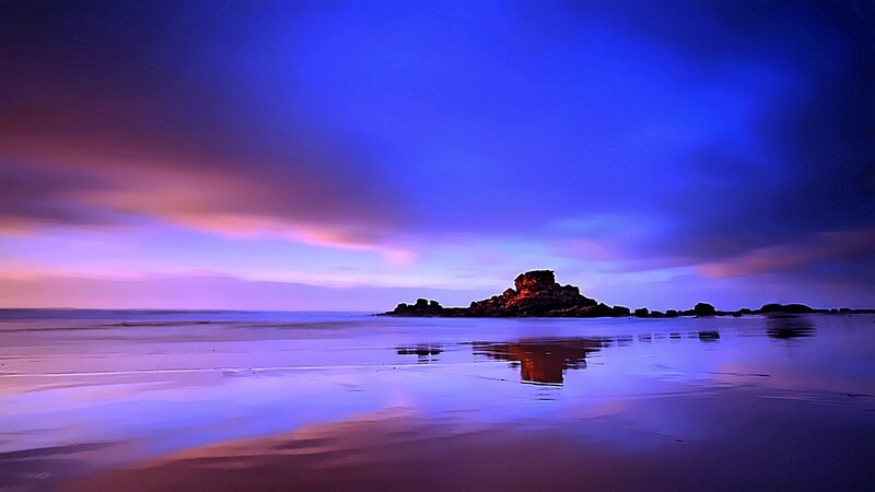 Purple sunset over coastal rocks