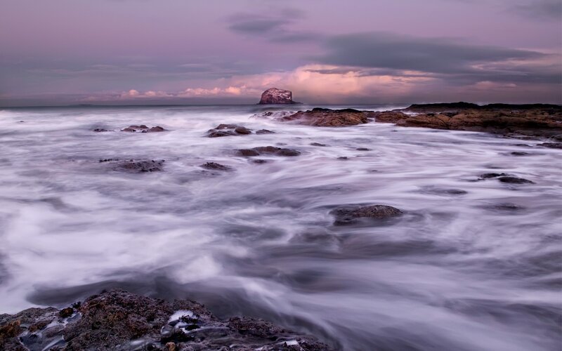 Purple sunset over coastal rocks