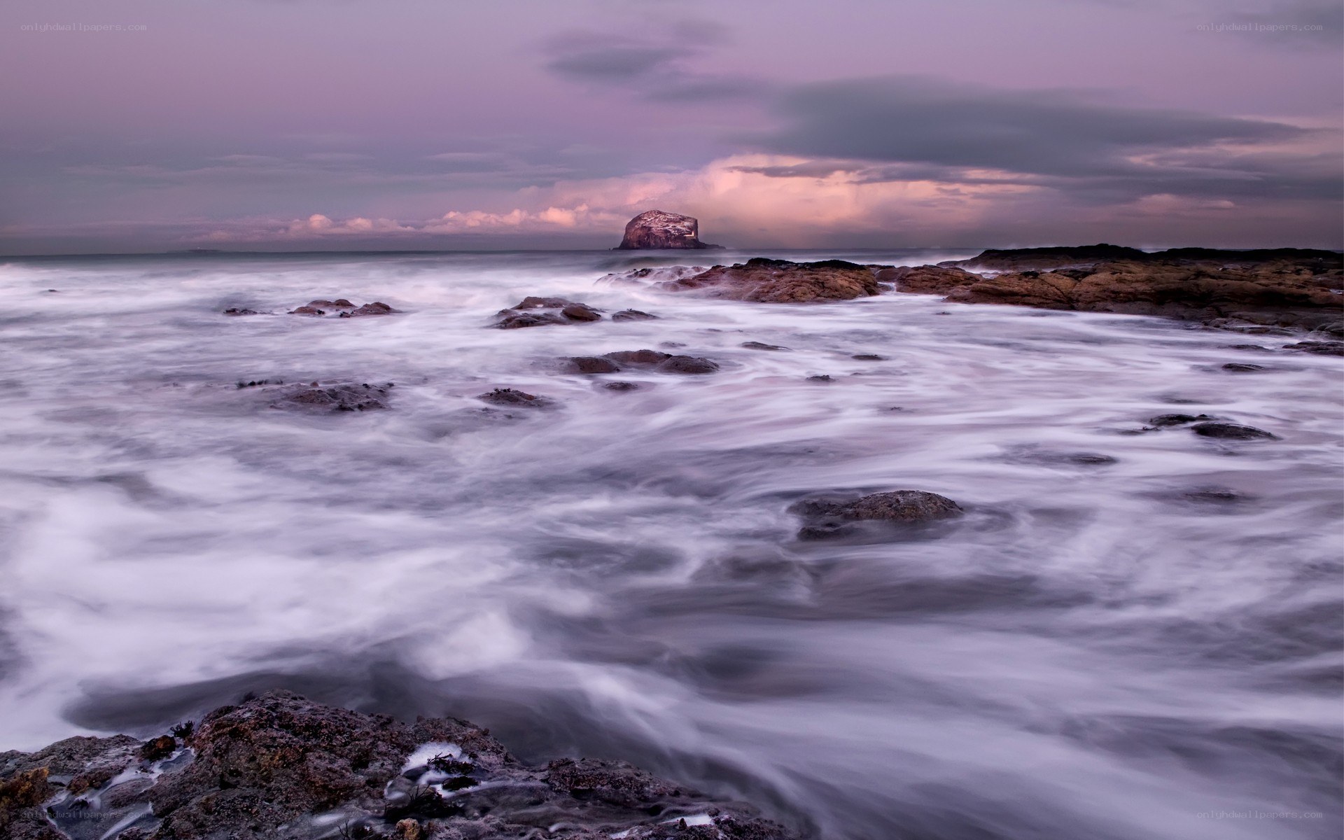 Purple sunset over coastal rocks