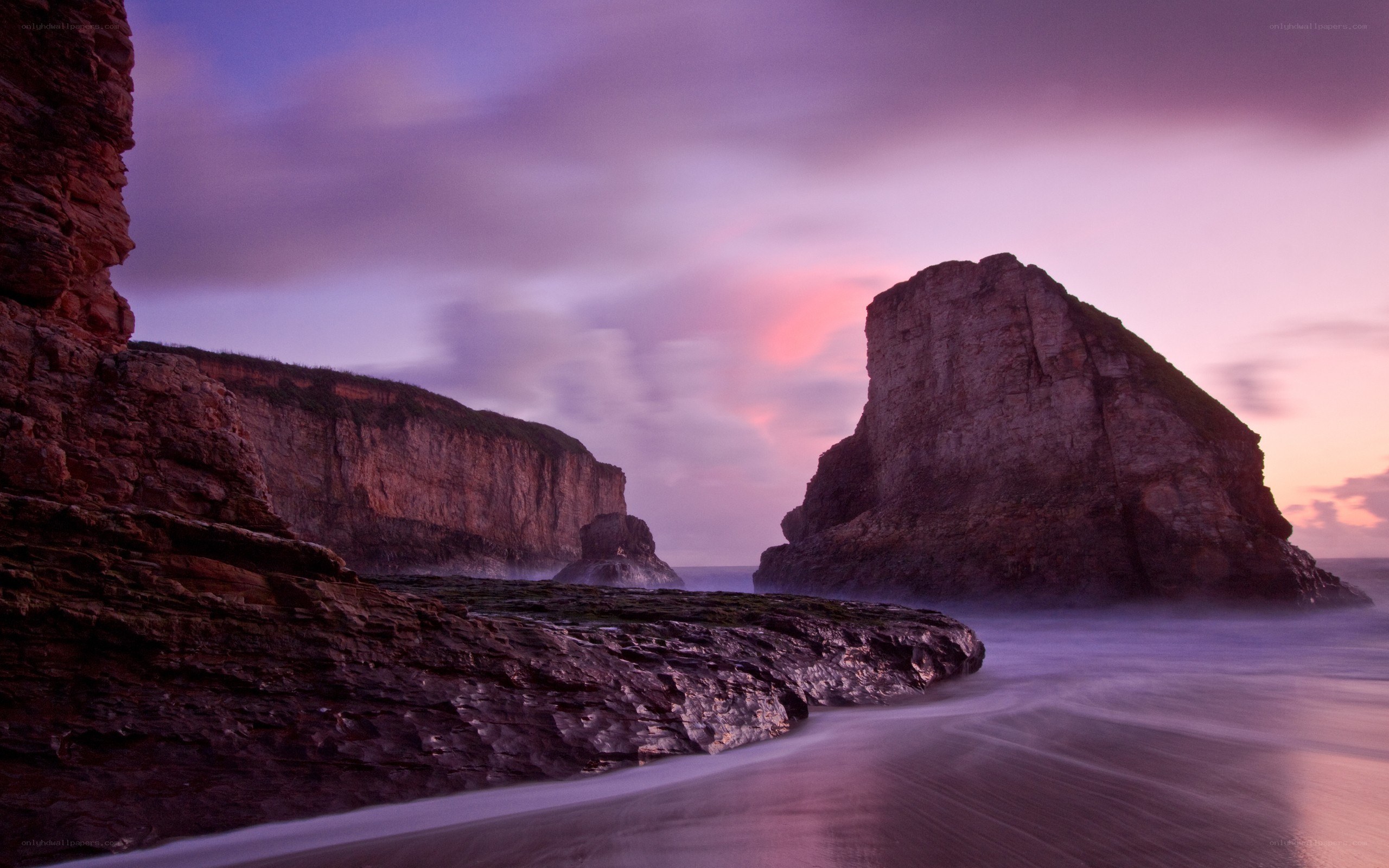 Purple sunset over coastal rocks