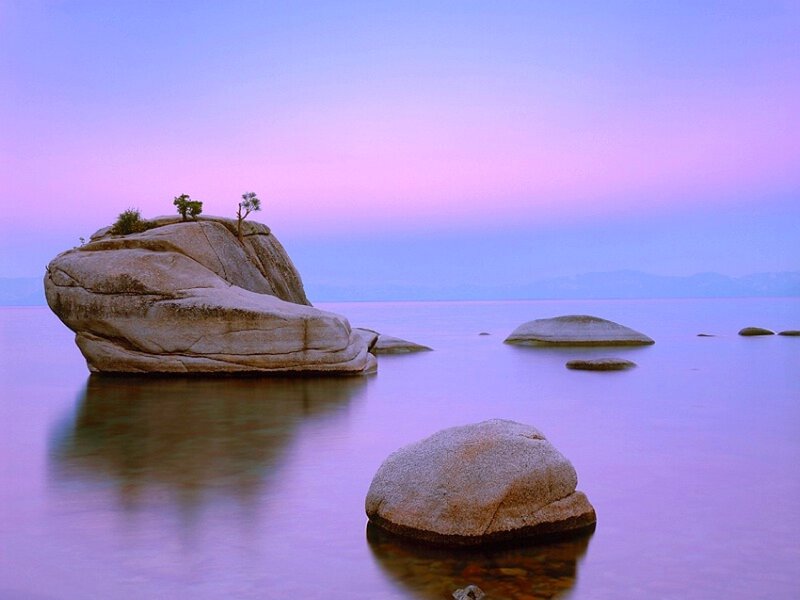 Purple sunset over lake rocks