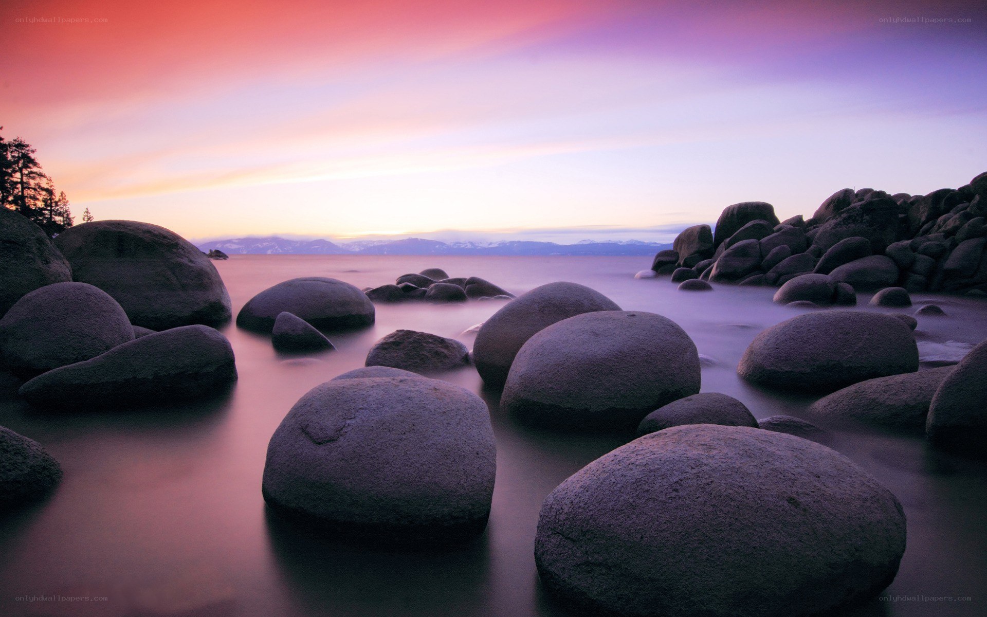 Purple sunset over lake rocks