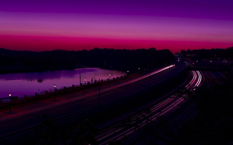 Purple sunset over river and highway