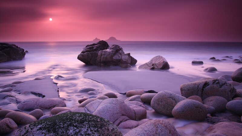 Purple sunset over rocky beach