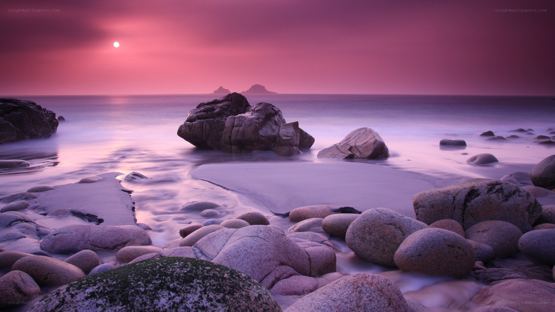 Purple sunset over rocky beach