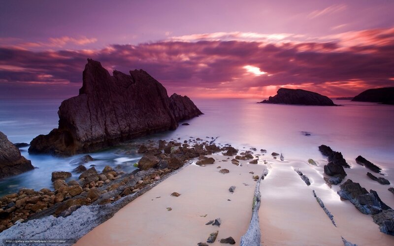 Purple sunset over rocky beach
