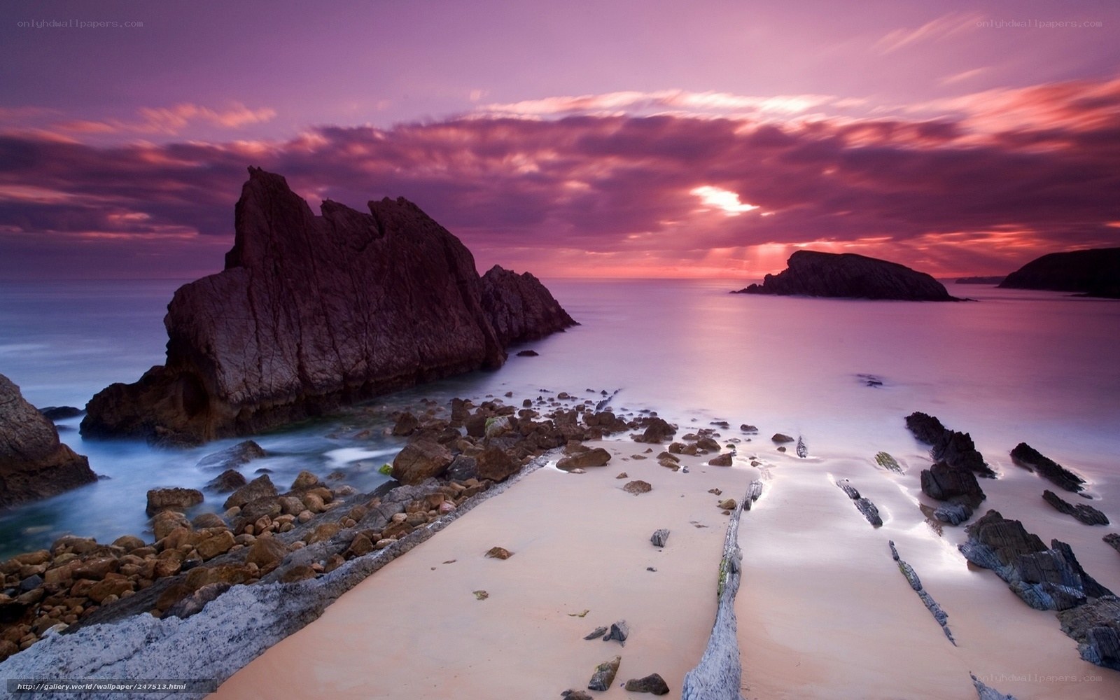 Purple sunset over rocky beach