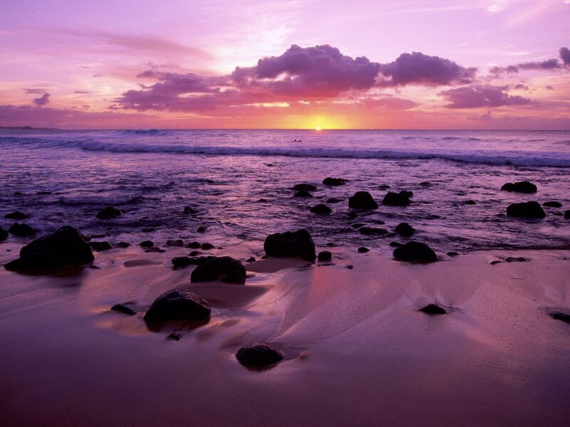 Purple sunset over rocky beach