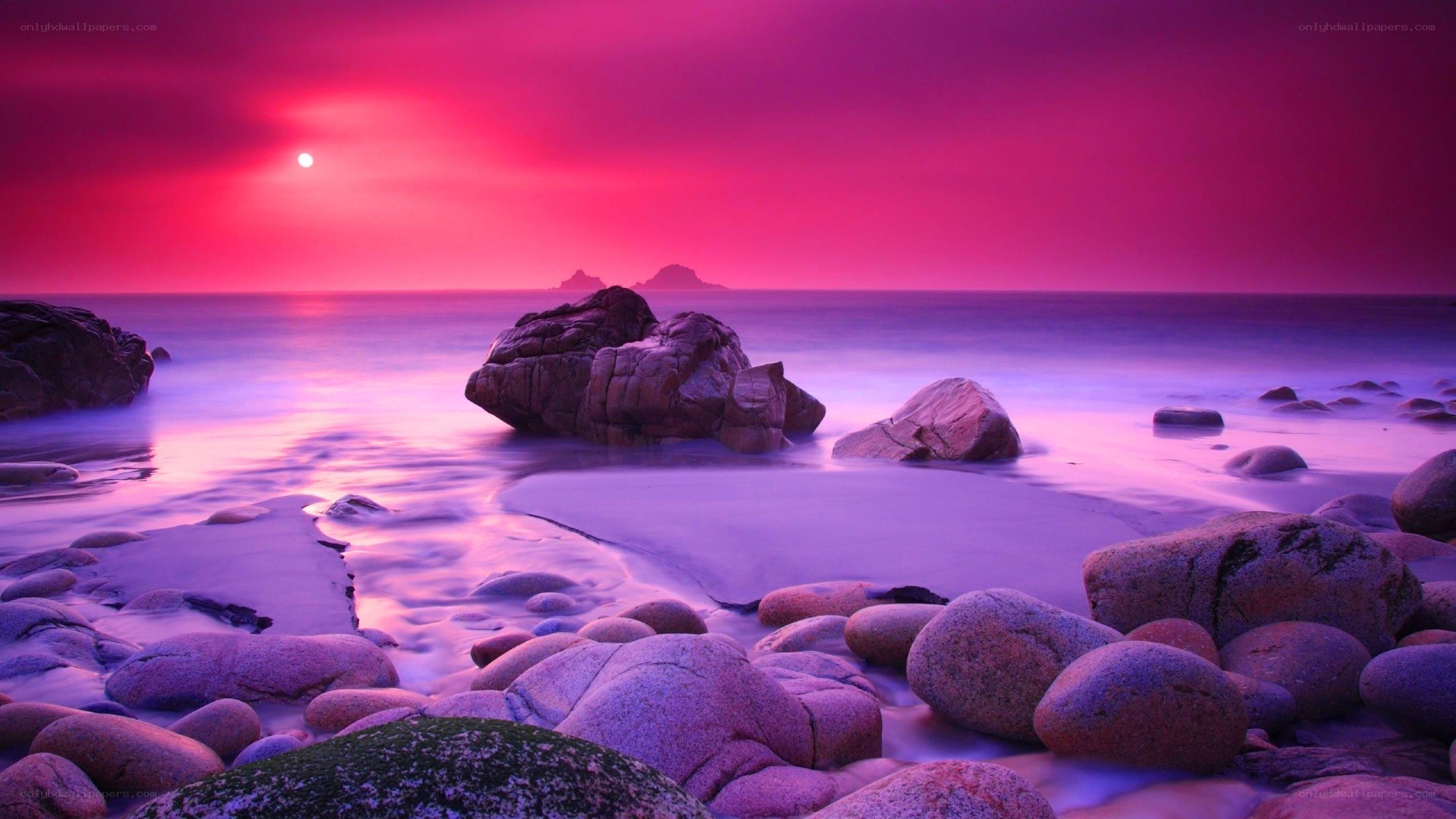 Purple sunset over rocky beach