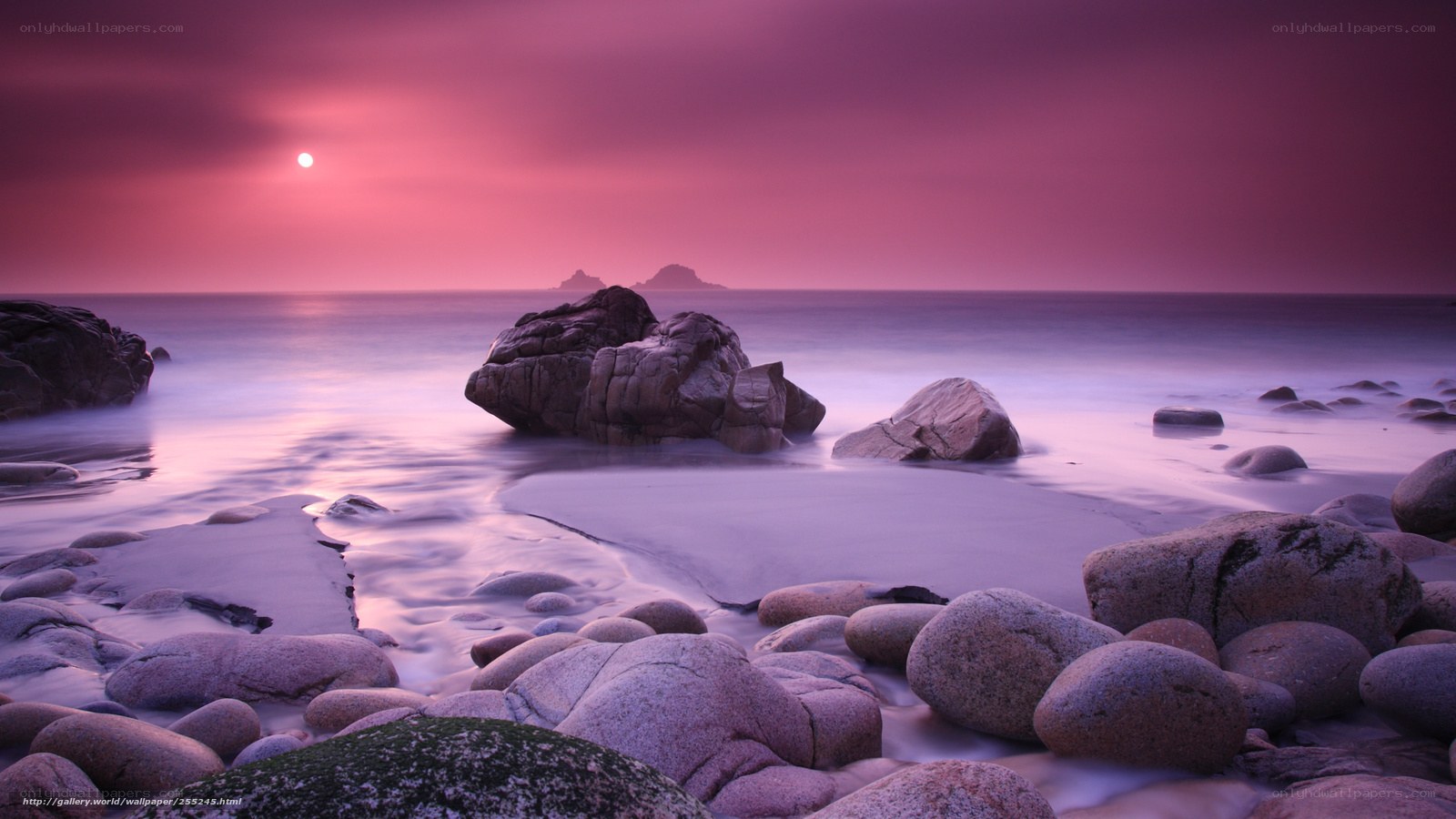 Purple sunset over rocky beach