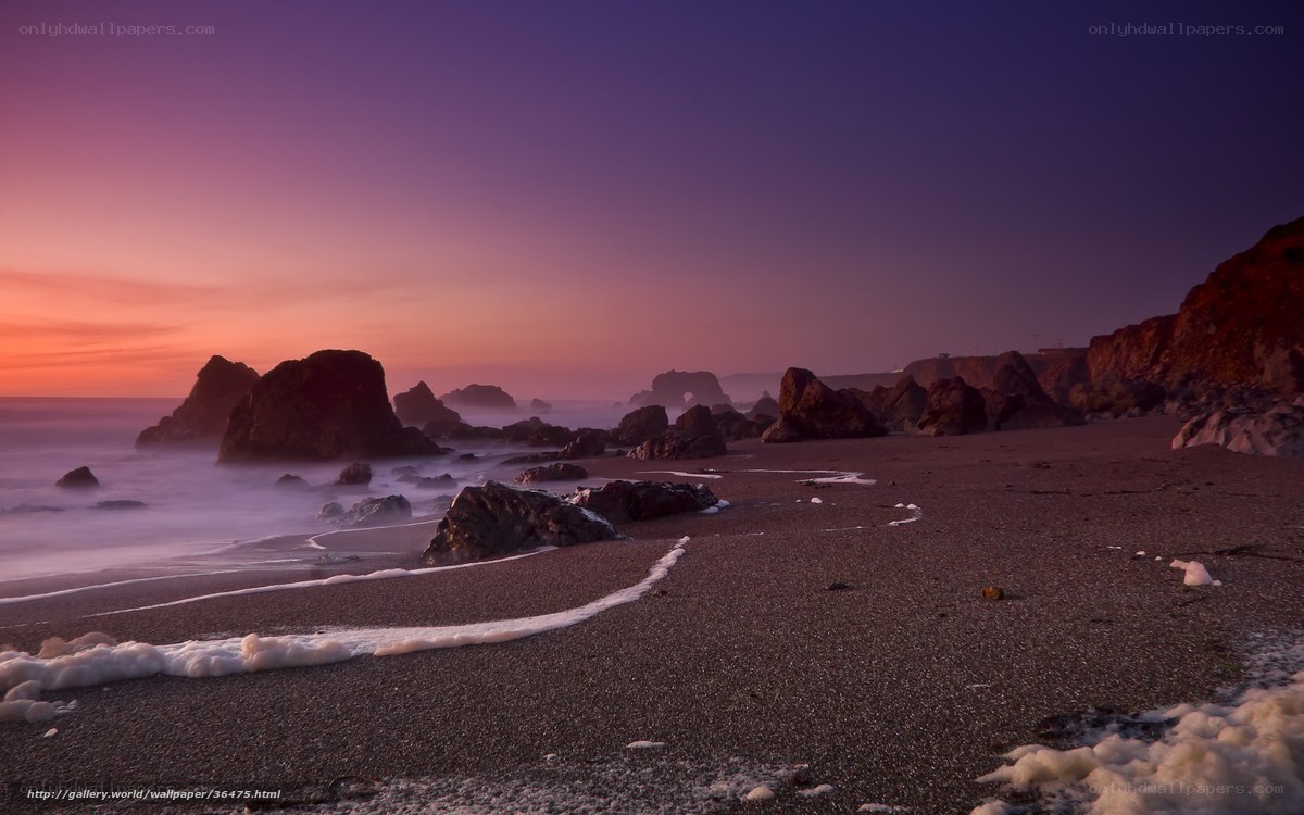 Purple sunset over rocky beach