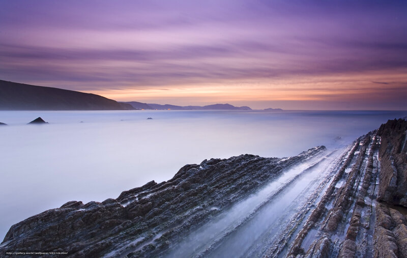 Purple sunset over rocky coast