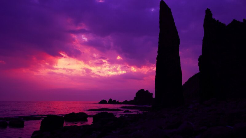 purple sunset over rocky coast
