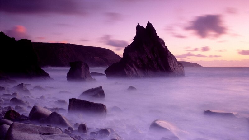 Purple sunset over rocky coast